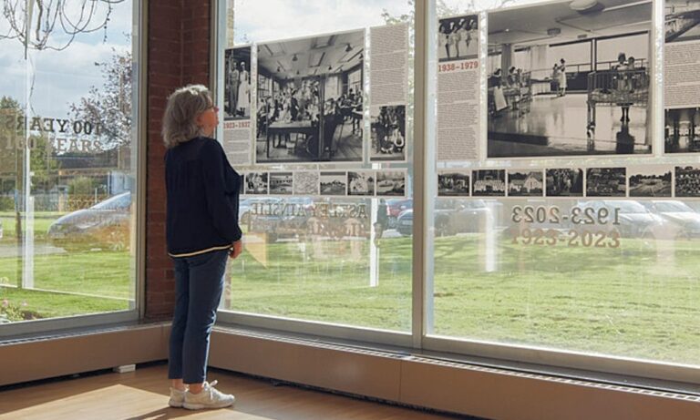 100 Year Exhibition - A member of staff examining display from inside